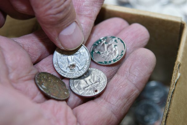 dirty coins in Rob Holsen’s hands