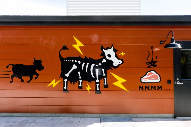Kühe und ein Steak: Wandmalerei an einem Facebook-Café