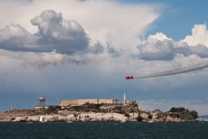 red double-decker plane flies over Alcatraz island