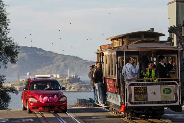 Lyft ride sharing car with mustache next to Cable Car in San Francisco