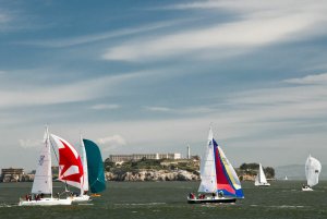 Sailboats competing in a regatta, racing past Alcatraz on the San Francisco Bay
