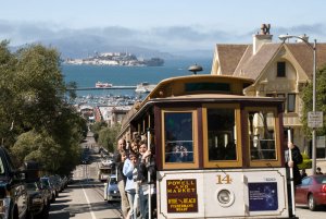 San Francisco’s iconic Cable Car heads up Hyde Street, with Alcatraz in the background