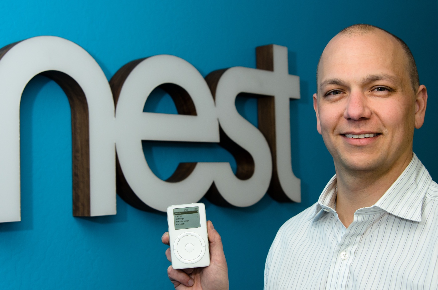 Former Apple executive Tony Fadell holds up an iPod in front of the logo of Nest, the smart home company he co-founded