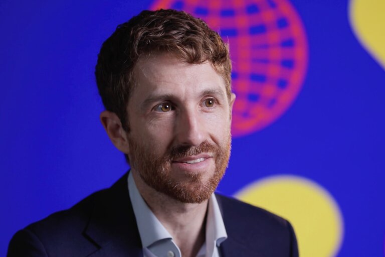Technology ethics expert Tristan Harris (Center for Humane Technology) seen during a backstage interview at the DLD Munich Conference 2025 in front of a screen showing the colorful blue, red and yellow conference design.
